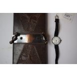 A lady's silver wristwatch, the enamel dial with Roman numerals, cracked, and a tie press,