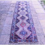 A Persian Yalameh runner, with floral motifs on a blue ground within a multi border,