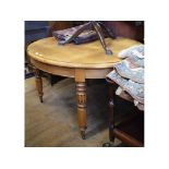 An oval oak dining table, on four carved legs,