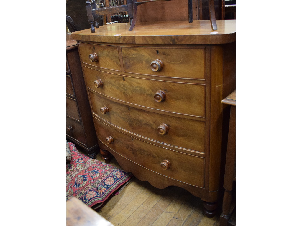 A 19th century mahogany bow front chest, of two short and three long drawers, on turned feet,