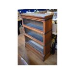 A Globe Wernicke style oak three section bookcase, 87 cm wide, two coffee tables, a glazed bookcase,