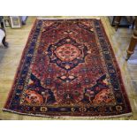 A Persian medallion rug, on a red ground, within a multi border,