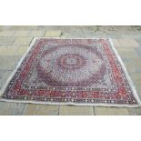 A Persian carpet, decorated a spreading central motif on a white ground, within a multi border,