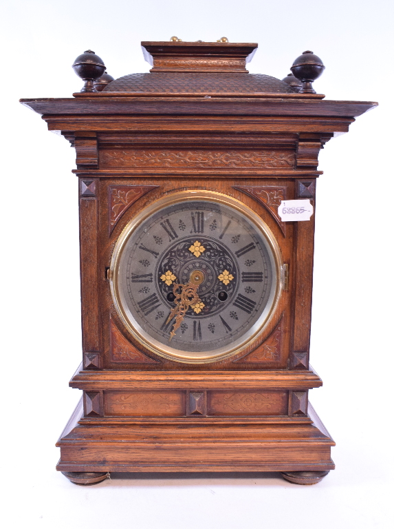 A Continental mantel clock, the 14 cm diameter metal dial with Roman numerals in an oak case,