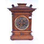 A Continental mantel clock, the 14 cm diameter metal dial with Roman numerals in an oak case,