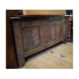 An 18th century carved oak coffer, decorated stylized fish and seaweed,