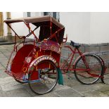 A cycle rickshaw or becak, with painted decoration,