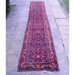 A Persian Mehraban runner, with floral motifs on a blue ground within a multi border,
