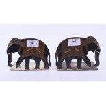 A pair of brass and enamel bookends, in the form of elephants,