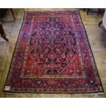 A Persian rug, decorated a central medallion on a red ground, within a multi border,