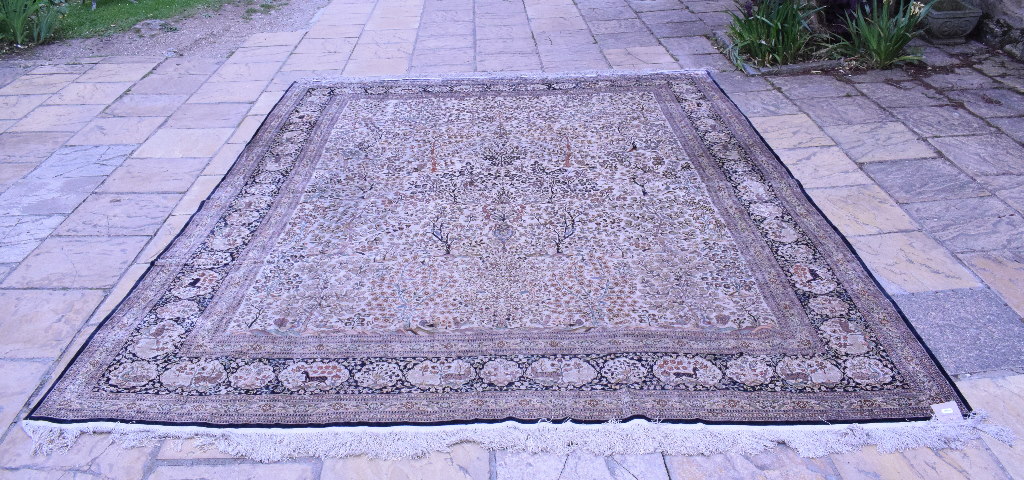 A silk carpet, decorated birds, flowers and foliage on an ivory ground,