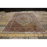A Persian Tabriz carpet, with central medallion and stylised floral motifs on a cream ground,
