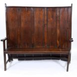 A George III country oak and pine settle, with a curve to one end,