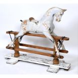 A late Victorian/Edwardian rocking horse, with traces of paint, on a stand,