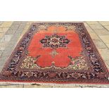 An Eastern carpet, with central medallion on a red ground within a multi border,