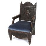 A late 19th century Burmese carved and pierced hardwood armchair, decorated a figure,