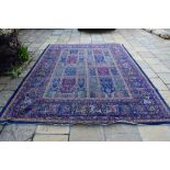 A Persian style carpet, decorated figures, animals and foliage, on a blue and purple ground,