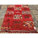 An Eastern rug, with geometric designs on a red ground,