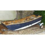 A navy blue painted wood lake boat, with a varnished interior, twin box seats and bilge pumps,