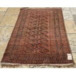 An Afghan rug, decorated ghul motifs on a red/orange ground, within a multi border,