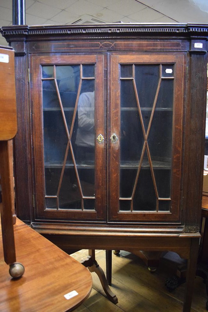 A George III inlaid oak corner cupboard, on a later stand,