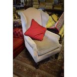 A 17th century style upholstered wing armchair