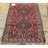 A Shiraz rug, with geometric motifs on an orange/red ground,