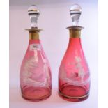 A pair of Mary Gregory style cranberry glass decanters and clear glass stoppers,