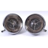 A pair of Lucas P100 headlamps, with bullseye lenses and chrome shells, signs of light pitting,