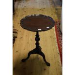 A mahogany tripod table, a pie crust top, on ball and claw feet,