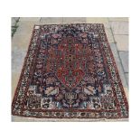 A Persian rug, with stylised floral motifs, on a blue ground,