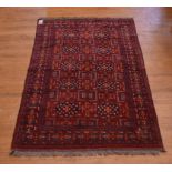 A Persian rug, stylised floral motifs on a red ground, within a multi border,
