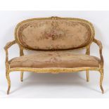 A Louis XVI style carved giltwood settee, with a floral needlework upholstered back and seat,