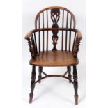 A 19th century Windsor style yew and elm kitchen armchair,