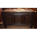 An oak coffer, carved flowers, foliage and lunettes,