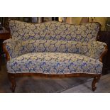 A Danish walnut upholstered three seater camel back settee, on cabriole front legs,