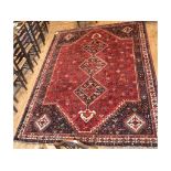 A Persian carpet, with three central medallions on a red ground,