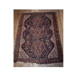 A Persian Shiraz rug, with three medallions on a blue ground, within a multi border,