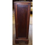 An oak pedestal collector's cabinet, having a panelled door enclosing eight graduated long drawers,