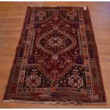A Persian rug, the central medallion on a red ground, within a multi border,