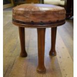 An Art Deco walnut stool, with leather upholstered top on three tapering legs, 34.