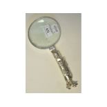 A magnifying glass, the handle in the form of a bag of golf clubs,