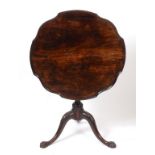 A mahogany tripod table, the shaped top with piecrust edge on a carved tripod base with claw feet,