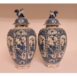 A pair of 19th century Dutch delft vases and covers, decorated birds and foliage, some loss/repair,