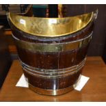 A mahogany bucket, of navette form, with a brass swing handle, liner and banding,