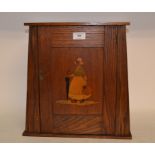 An Arts and Crafts style oak smokers cabinet, the panel door inlaid a Dutch lady,
