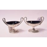 A pair of silver coloured metal two handled vase shaped salt cellars, marks rubbed,