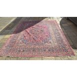 A Persian carpet, decorated a central floral medallion on a pink ground, within a multi border,