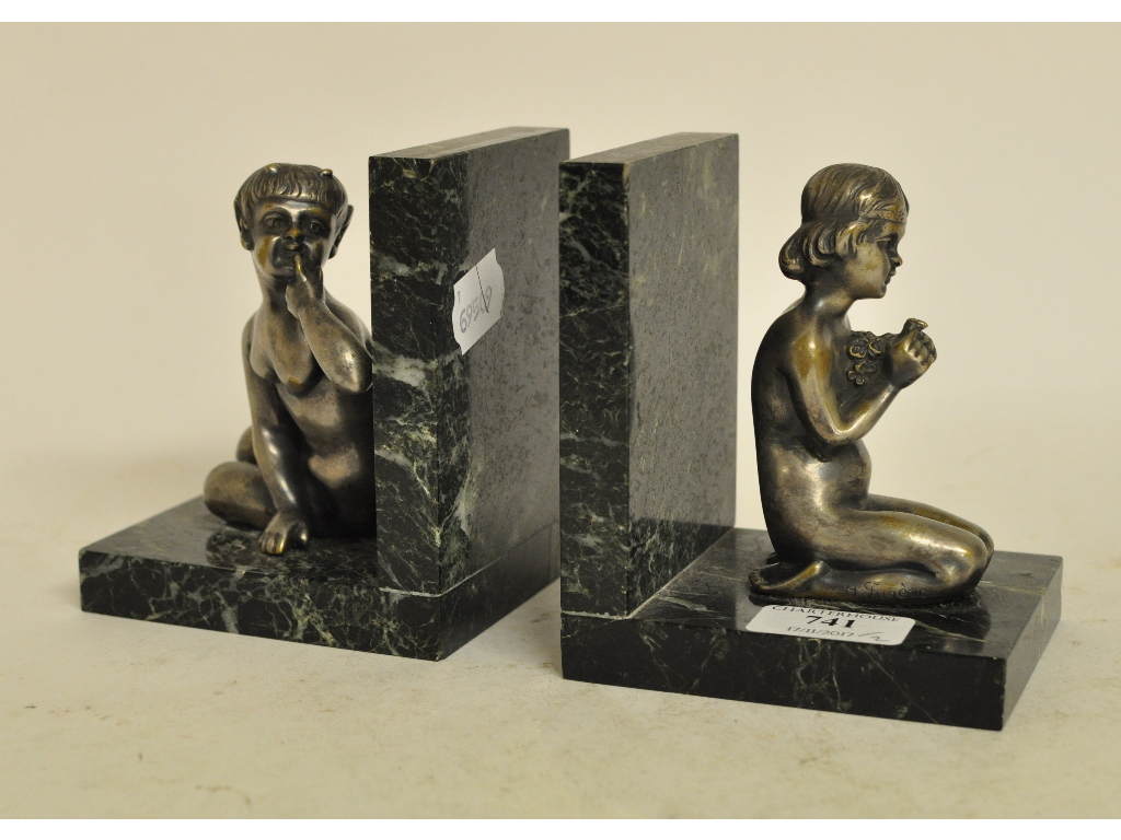 A pair of silvered cast metal and marble figural bookends, after Henri Fugere,