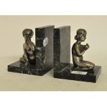 A pair of silvered cast metal and marble figural bookends, after Henri Fugere,